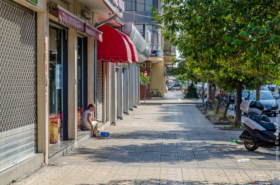 Une jeune fille sur le pas de la porte d'un magasin à Tirana