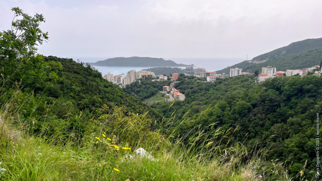 View of the Montenegrin resort of Bečići from Ivanovići Cave. Buildings, greenery, and the sea are visible.