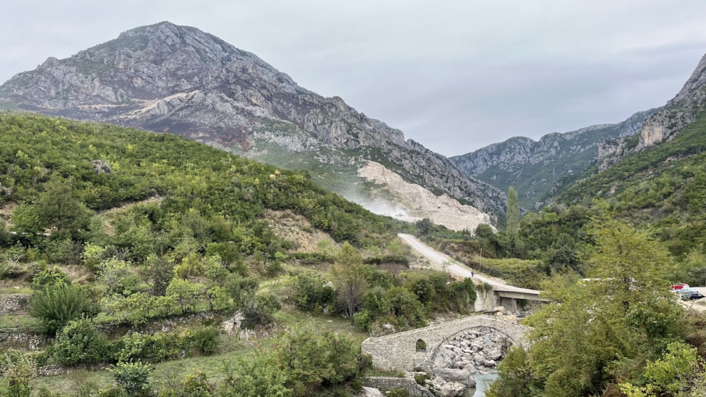 Панорама реки, каменного моста Курчай, окружающих гор и карьера вдали.